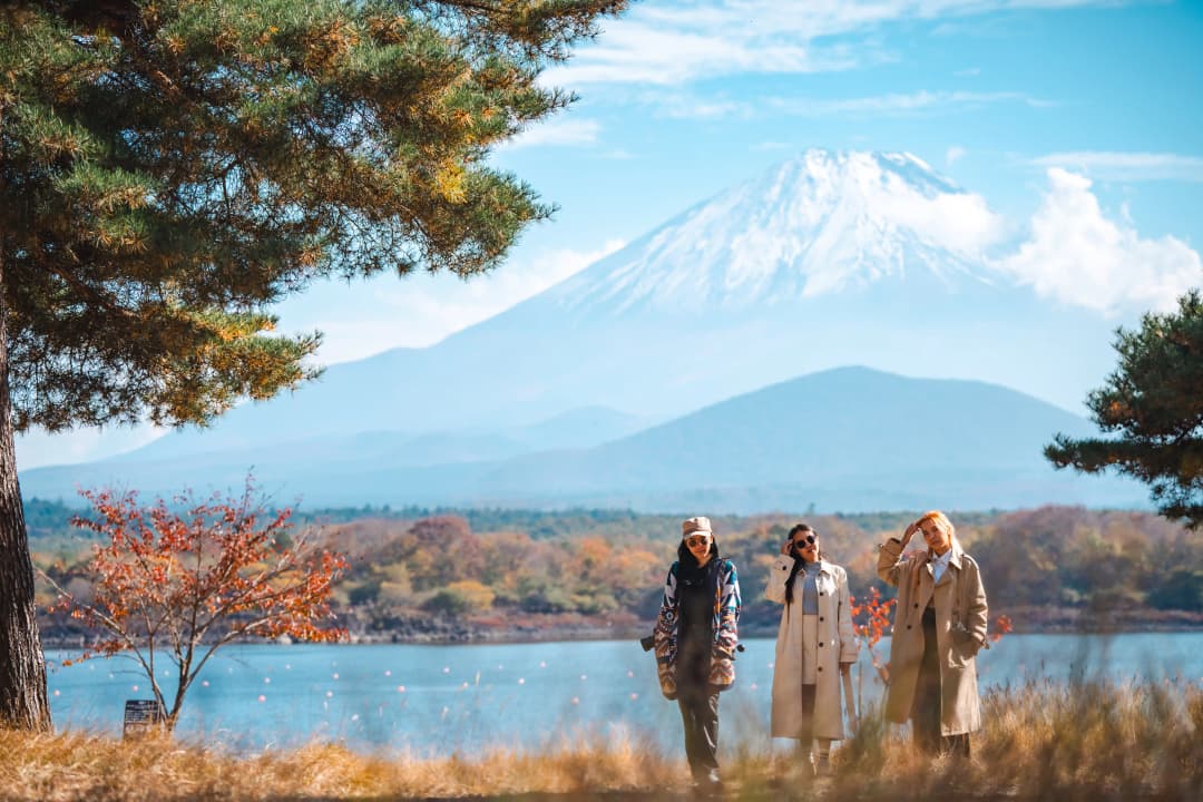 happy female tourists enjoying mount Fuji landscape autumn leaves
